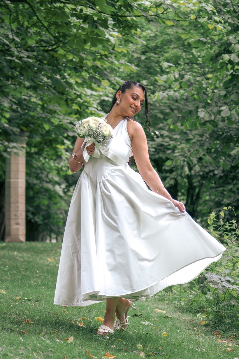 La mariée fait voler sa robe dans un parc