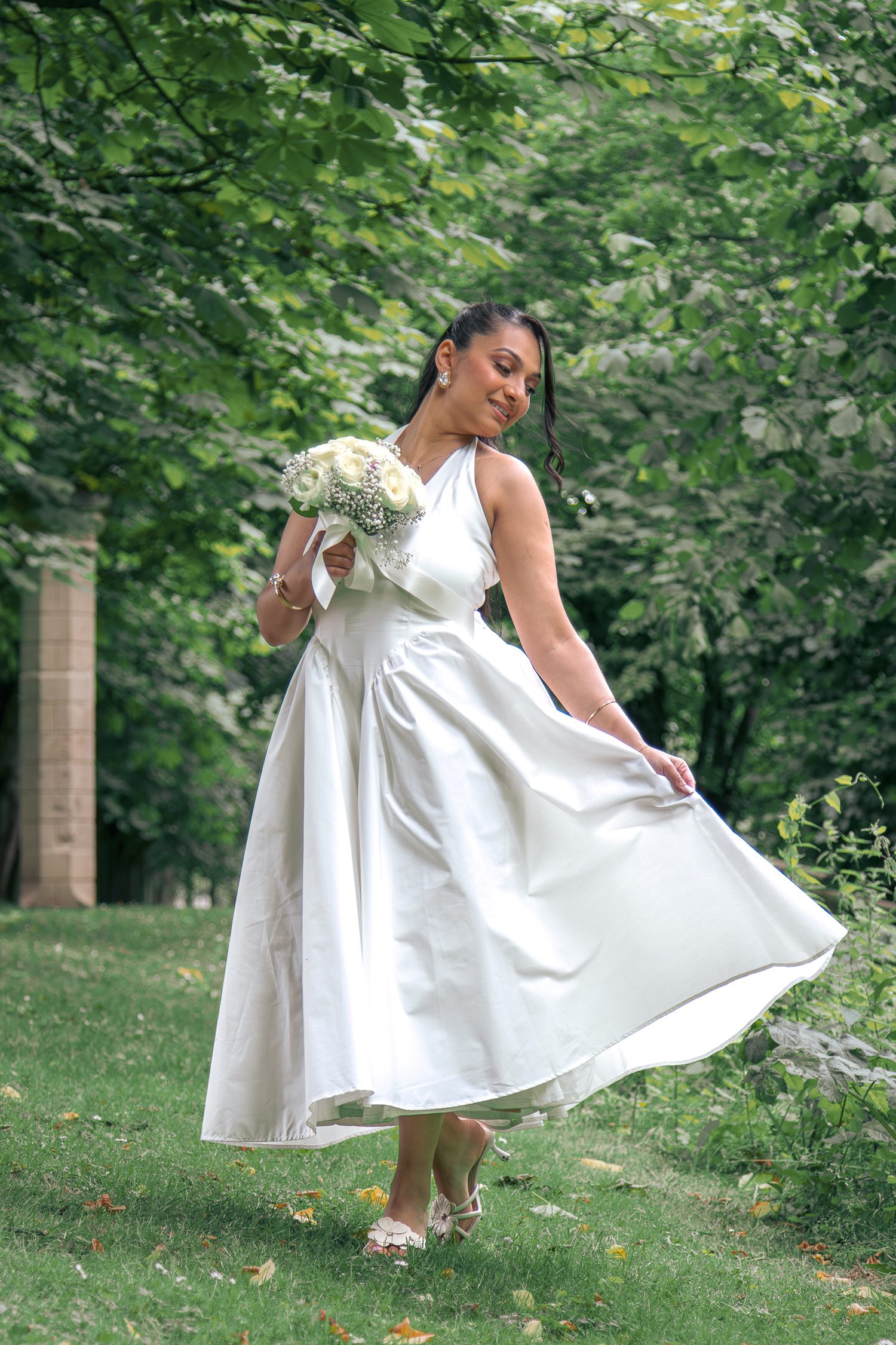 La mariée fait voler sa robe dans le parc