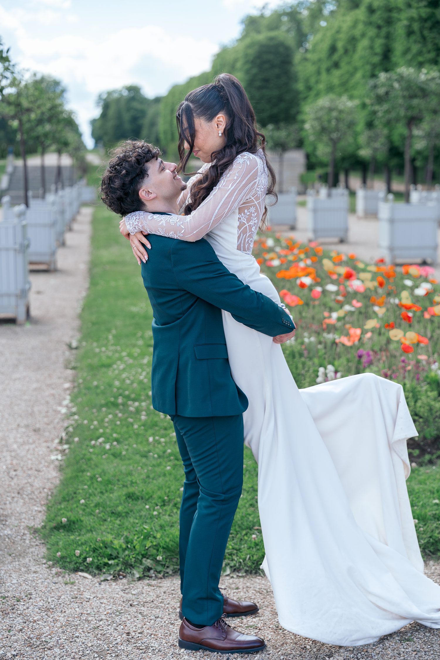 Le marié soulève la mariée dans ses bras devant un parterre de coquelicots