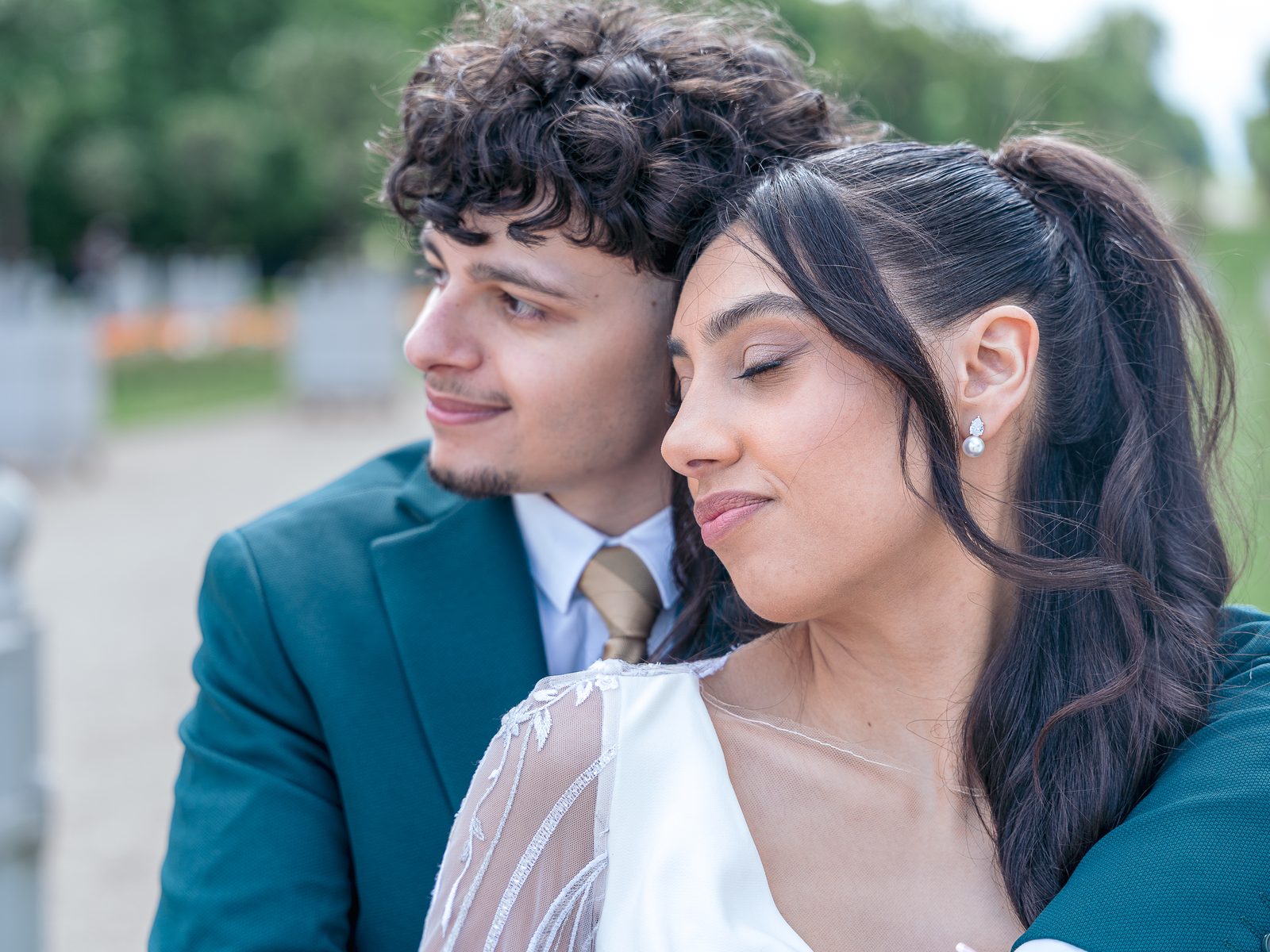 La mariée pose sa tête contre le marié, tous deux regardent au loin